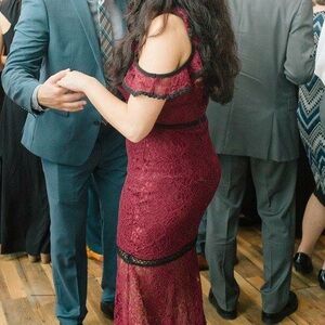 Wine red lace dress with black trim, floor length. Below the knee is sheer.